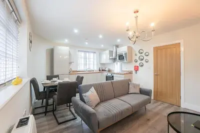 a living room and kitchen with a couch and a table at The Queens Arms Apartments in Liverpool