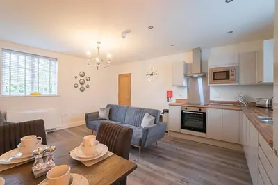 a kitchen and living room with a couch and a table at The Queens Arms Apartments in Liverpool