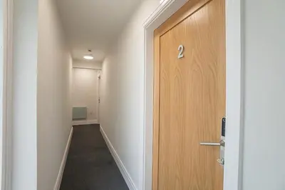 a hallway with a wooden door in a room at The Queens Arms Apartments in Liverpool
