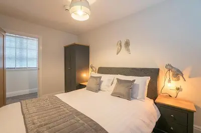 a bedroom with a large bed with white sheets and pillows at The Queens Arms Apartments in Liverpool