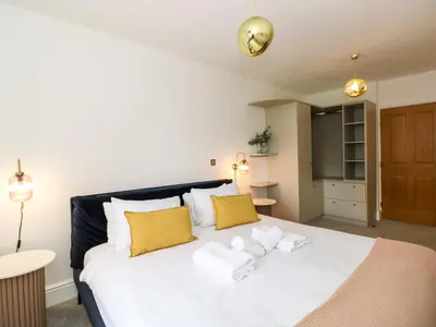 a bedroom with a large white bed with yellow pillows at The Violet Suite Stone Cross Mansion in Ulverston