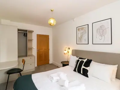 a bedroom with a white bed and a television at The Violet Suite Stone Cross Mansion in Ulverston