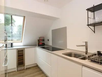a white kitchen with a sink and a window at The Arthur Suite Stone Cross Mansion in Ulverston