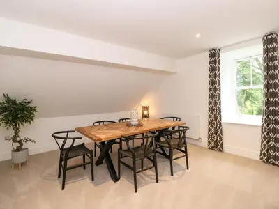a dining room with a wooden table and chairs at The Arthur Suite Stone Cross Mansion in Ulverston