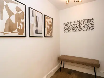 a bench in a room with pictures on the wall at The Arthur Suite Stone Cross Mansion in Ulverston