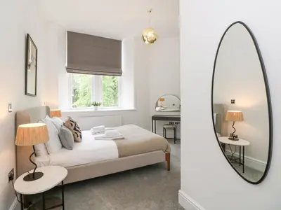 a bedroom with a bed and a mirror at The Elizabeth Suite Stone Cross Mansion in Ulverston
