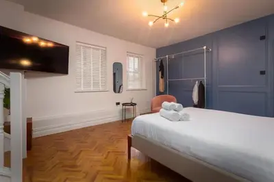 a bedroom with a white bed and blue walls at Capri Stays - Apartment One in Blackpool
