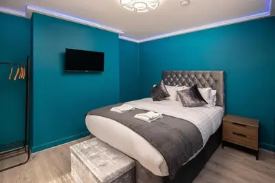 a bedroom with a bed with a blue wall at Town View Apartment by Sasco in Blackpool