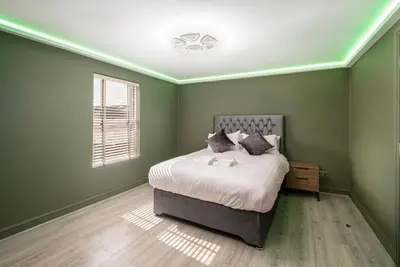 a green bedroom with a bed and a window at Town View Apartment by Sasco in Blackpool