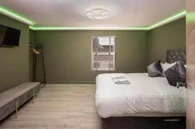 a bedroom with a large bed with green lighting at Town View Apartment by Sasco in Blackpool