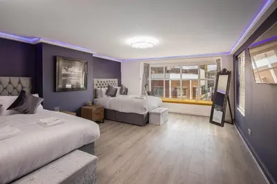 a hotel room with two beds and a window at Town View Apartment by Sasco in Blackpool