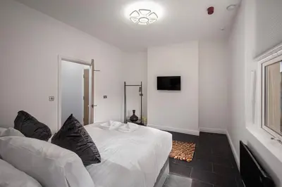 a white bedroom with a white bed and a window at Town View Apartment by Sasco in Blackpool