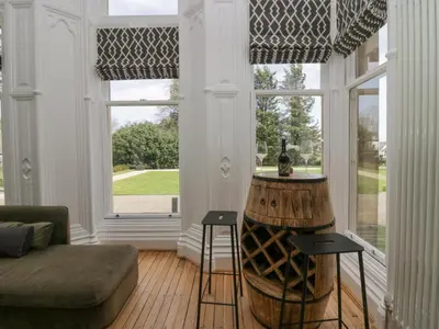 a living room with a large window and a couch at The Myles Suite Stone Cross Mansion in Ulverston