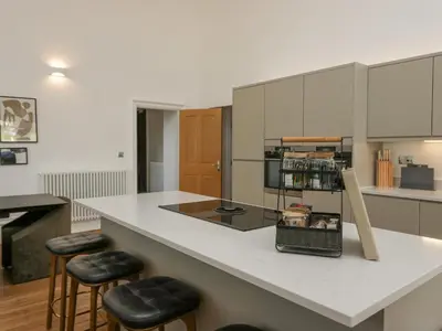 a kitchen with a counter with stools and a counter top at The Myles Suite Stone Cross Mansion in Ulverston
