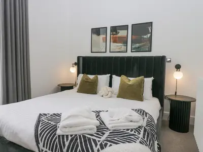 a bedroom with a bed with towels on it at The Myles Suite Stone Cross Mansion in Ulverston