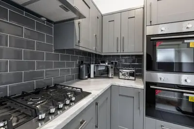 a kitchen with white cabinets and a stove top oven at The Anfield Inn in Liverpool