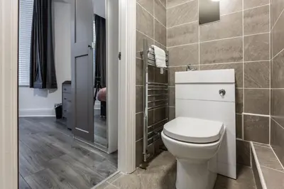a bathroom with a toilet and a walk in shower at The Anfield Inn in Liverpool