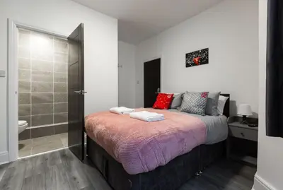 a bedroom with a large bed and a bathroom at The Anfield Inn in Liverpool