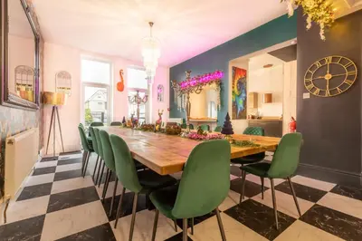 a dining room with a long table and green chairs at Empress Hall Blackpool by Charles Alexander Short Stay - Sleeps 20 in Blackpool