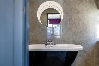 a bathroom with a sink and a mirror at Empress Hall Blackpool by Charles Alexander Short Stay - Sleeps 20 in Blackpool