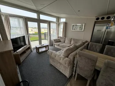 a living room with a couch and a table and a television at Lake District Willerby Vogue Lodge, Lake View on Haven Lakeland Gold Grade in Flookburgh