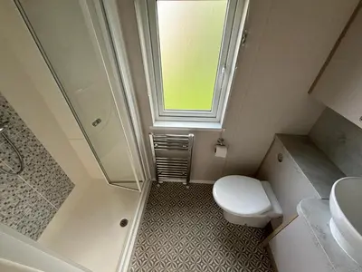 a small bathroom with a toilet and a window at Lake District Willerby Vogue Lodge, Lake View on Haven Lakeland Gold Grade in Flookburgh