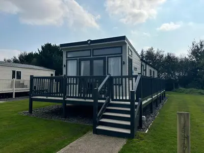 a black trailer with a staircase in a yard at Lake District Willerby Vogue Lodge, Lake View on Haven Lakeland Gold Grade in Flookburgh