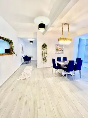 a dining room with a table and blue chairs at Winter Gardens Presidential Suite Blackpool in Blackpool