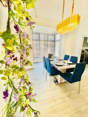 a dining room with a table and chairs and flowers at Winter Gardens Presidential Suite Blackpool in Blackpool