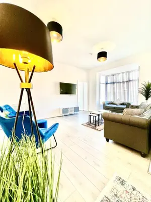 a living room with a couch and a lamp at Winter Gardens Presidential Suite Blackpool in Blackpool