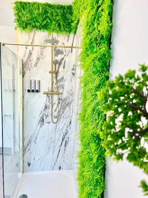 a bathroom with green ivy on the wall at Winter Gardens Presidential Suite Blackpool in Blackpool