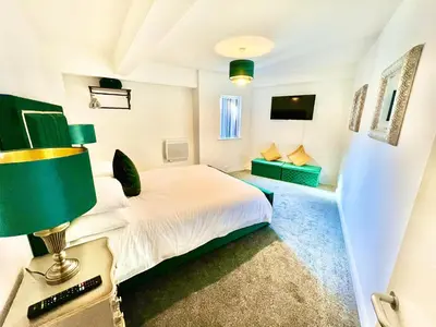 a bedroom with a bed and a table with a lamp at Winter Gardens Owners Suite Blackpool in Blackpool