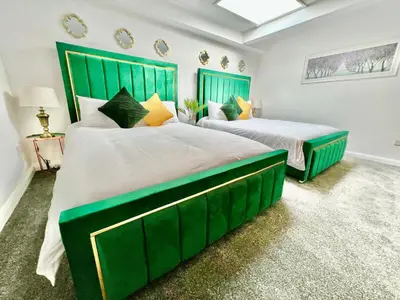two beds with green headboards in a bedroom at Winter Gardens Owners Suite Blackpool in Blackpool