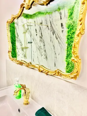 a mirror on a wall above a bathroom sink at Winter Gardens Owners Suite Blackpool in Blackpool