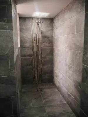 a shower in a bathroom with gray tiles at New Oxford House Apartments By Happy Days in Liverpool