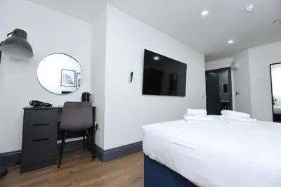a bedroom with a bed and a desk and a mirror at New Oxford House Apartments By Happy Days in Liverpool