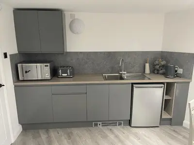 a kitchen with white cabinets and a sink and a counter at The Welcome Apartment in Blackpool