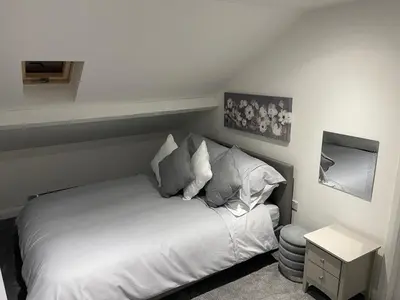 a bedroom with a white bed with pillows at The Welcome Apartment in Blackpool