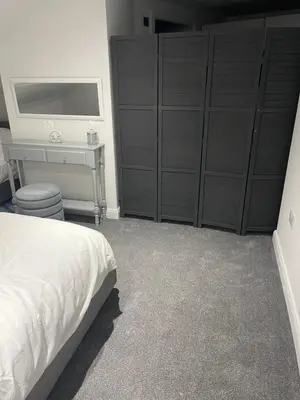 a bedroom with a bed and a desk and cabinets at The Welcome Apartment in Blackpool