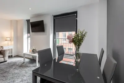 a dining room table with a vase of flowers on it at RST Cumberland Street in Liverpool