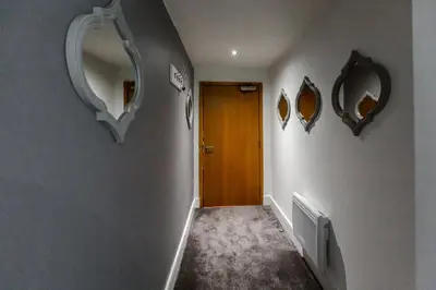 a hallway with three mirrors on the wall and a door at RST Cumberland Street in Liverpool