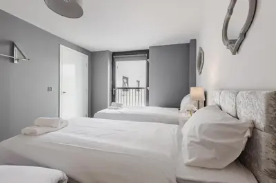 a white bedroom with two beds and a couch at RST Cumberland Street in Liverpool