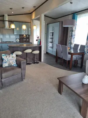 a kitchen and living room with a couch and a table at Pemberton Arrondale Lodge, Lakeside View (Haven Lakeland) in Flookburgh