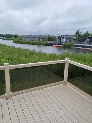 a wooden deck with a view of a river at Pemberton Arrondale Lodge, Lakeside View (Haven Lakeland) in Flookburgh