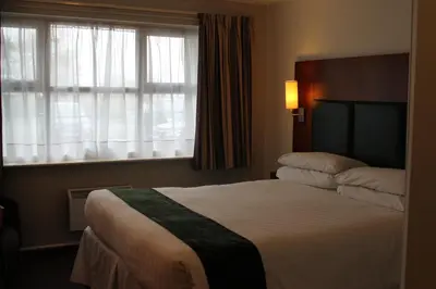 a hotel room with a bed and a window at The Villa Express in Kirkham