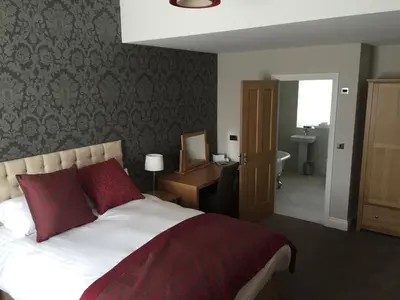 a bedroom with a bed and a desk and a bathroom at The Villa Express in Kirkham