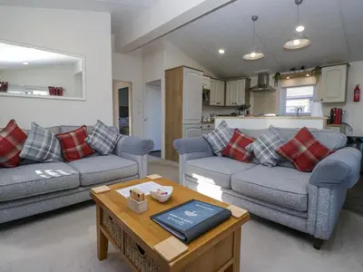 a living room with two couches and a table at Lakeland Dream South Lakeland Leisure Lodge in Carnforth
