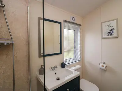 a bathroom with a sink and a glass shower at Lakeland Dream South Lakeland Leisure Lodge in Carnforth