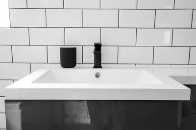 a white sink in a white tiled bathroom at Withnell Stays - Apartment Six in Blackpool