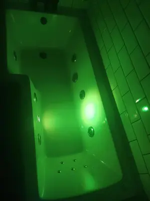 a green bath tub with a green light on it at Withnell Stays - Apartment Six in Blackpool